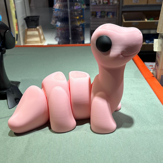 Pink toy dinosaur on a green surface with a store setting in the background